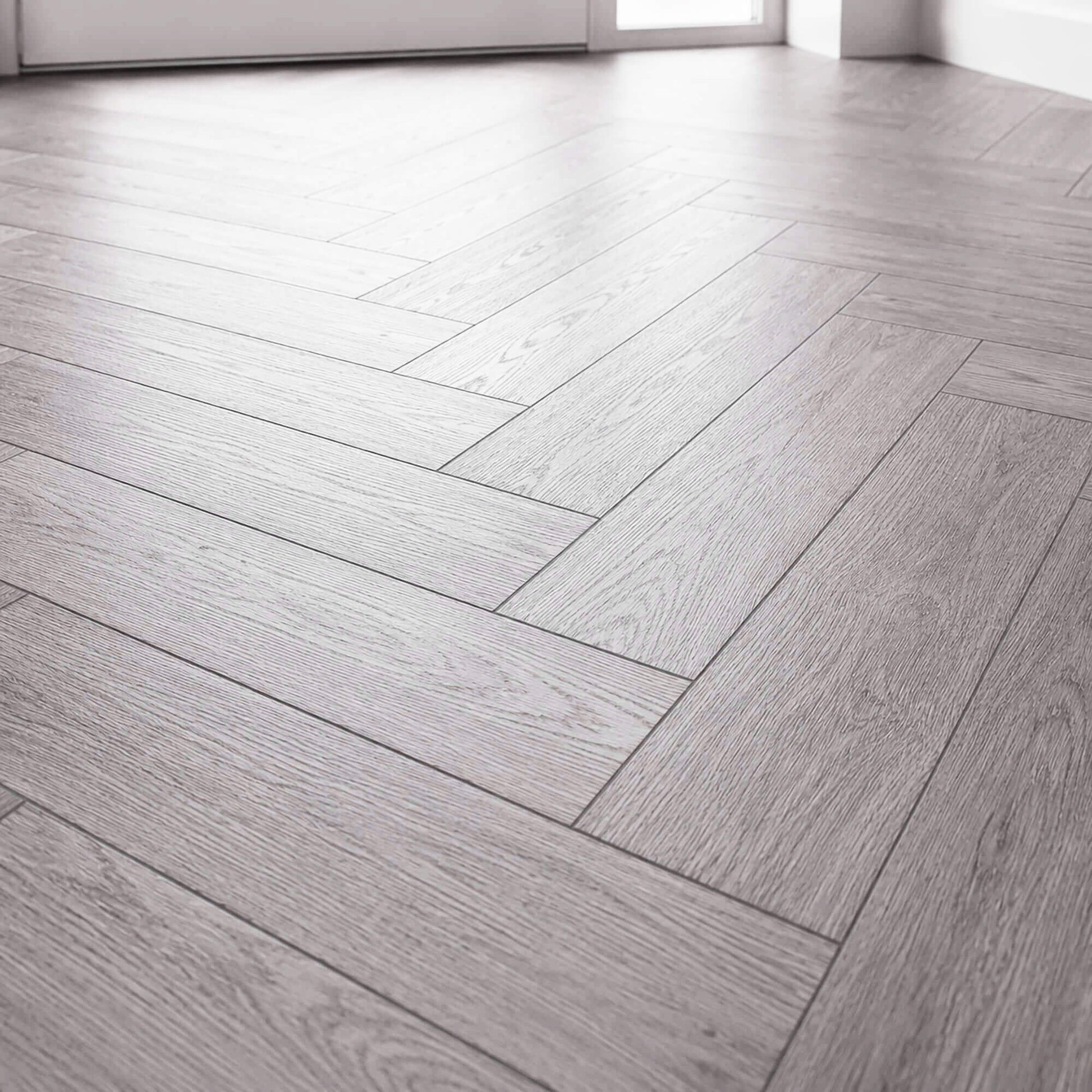 Close-up of Alsace Oak Rigid LVT Herringbone flooring in a home hallway.