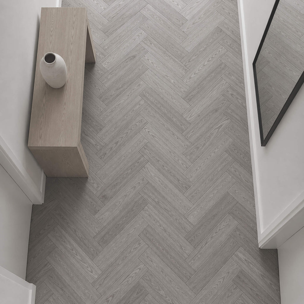 Elevated view of Alsace Oak Rigid LVT Herringbone flooring in a home hallway setting.