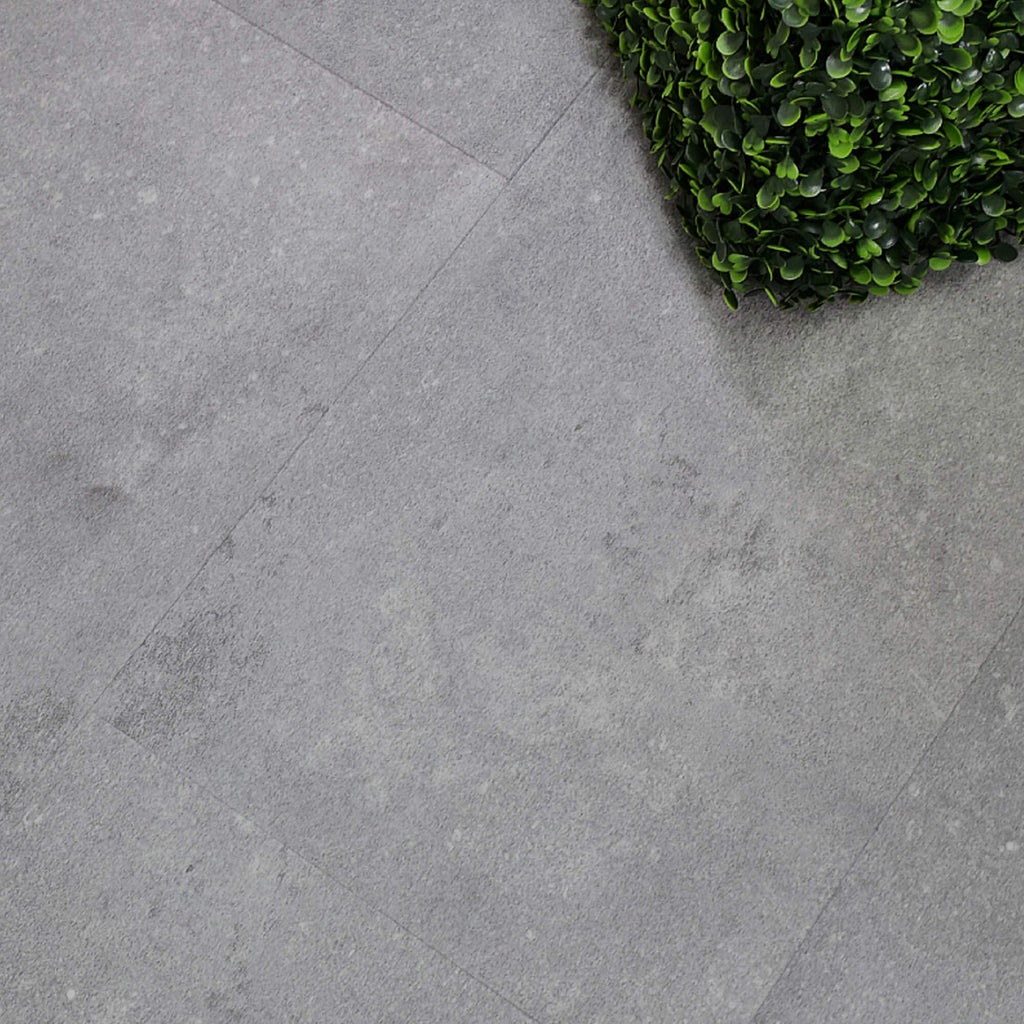 Claros Grey Rigid LVT Tile Flooringwith a green plant in the corner