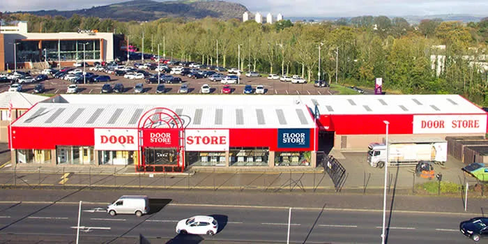 Red and white store with 'Door Store' branding on a city street.
