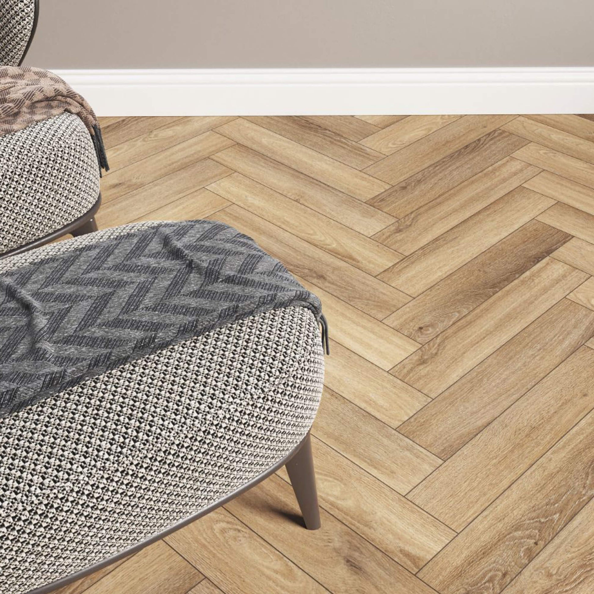 Forest Oak Rigid LVT Herringbone Flooring with a textured seat and ottoman in a living room setting.