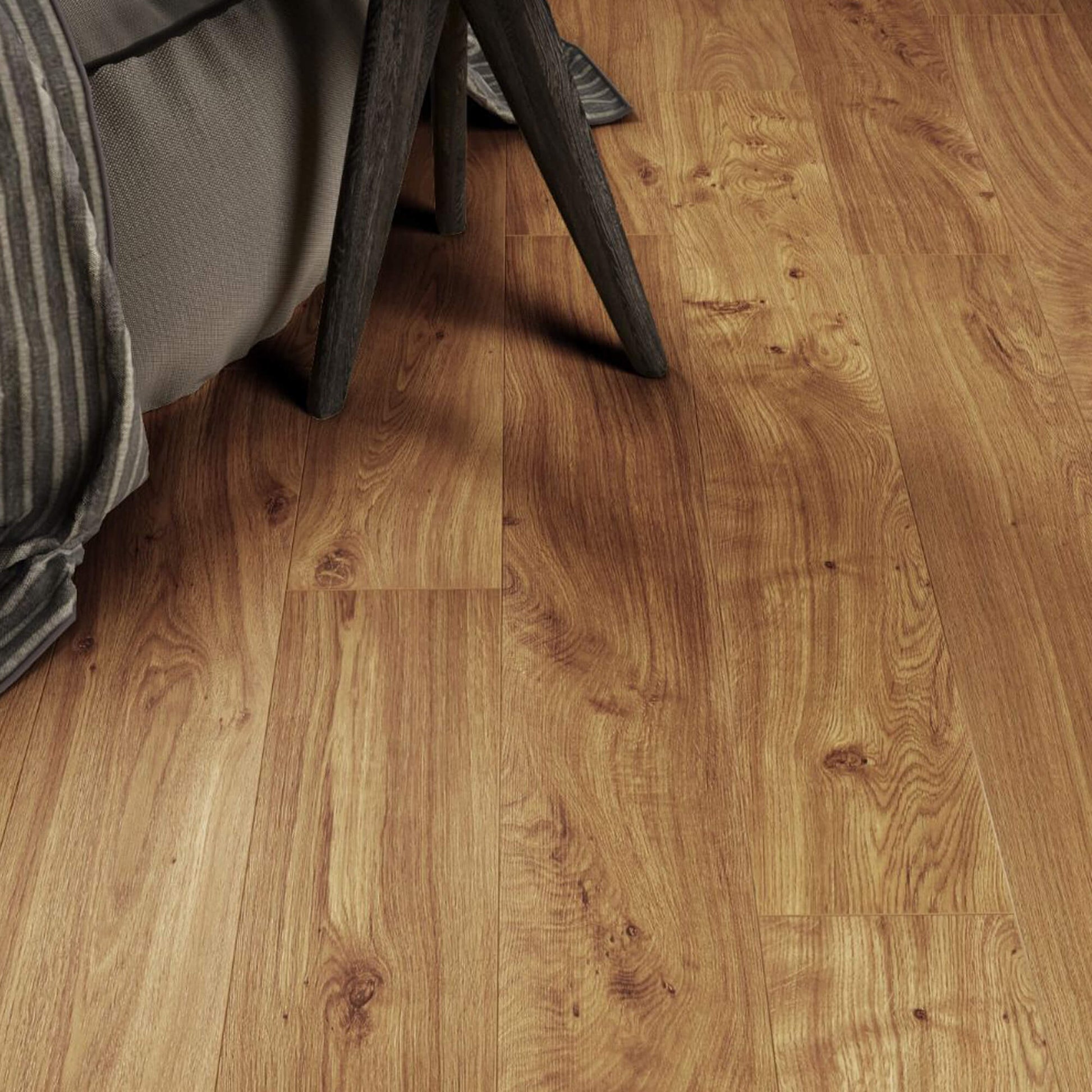 Groovy Oak Country Laminate Flooring in a living room setting with a sofa and legs of a table.