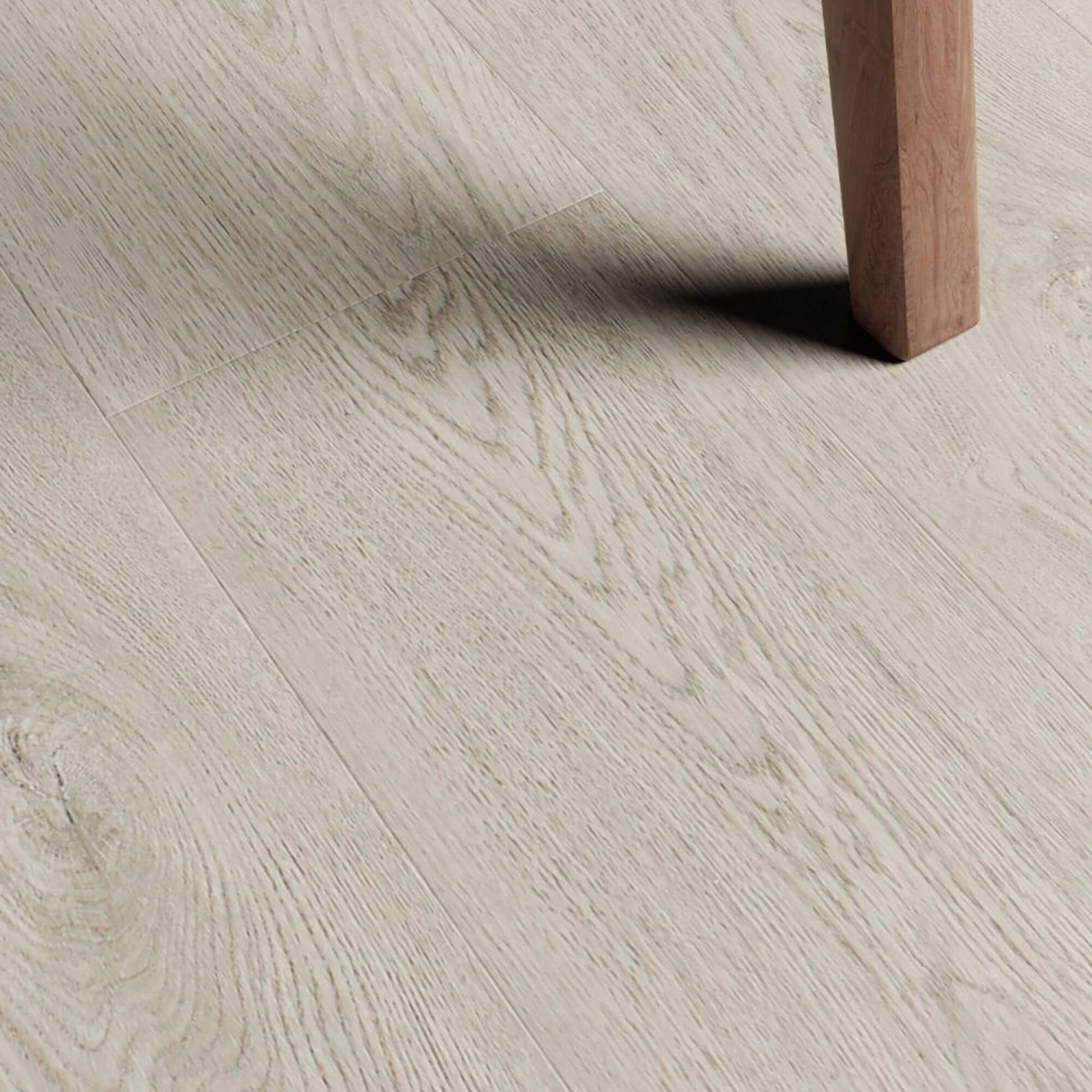 Close-up of Marino Grey Rigid LVT flooring with a wooden leg partially visible