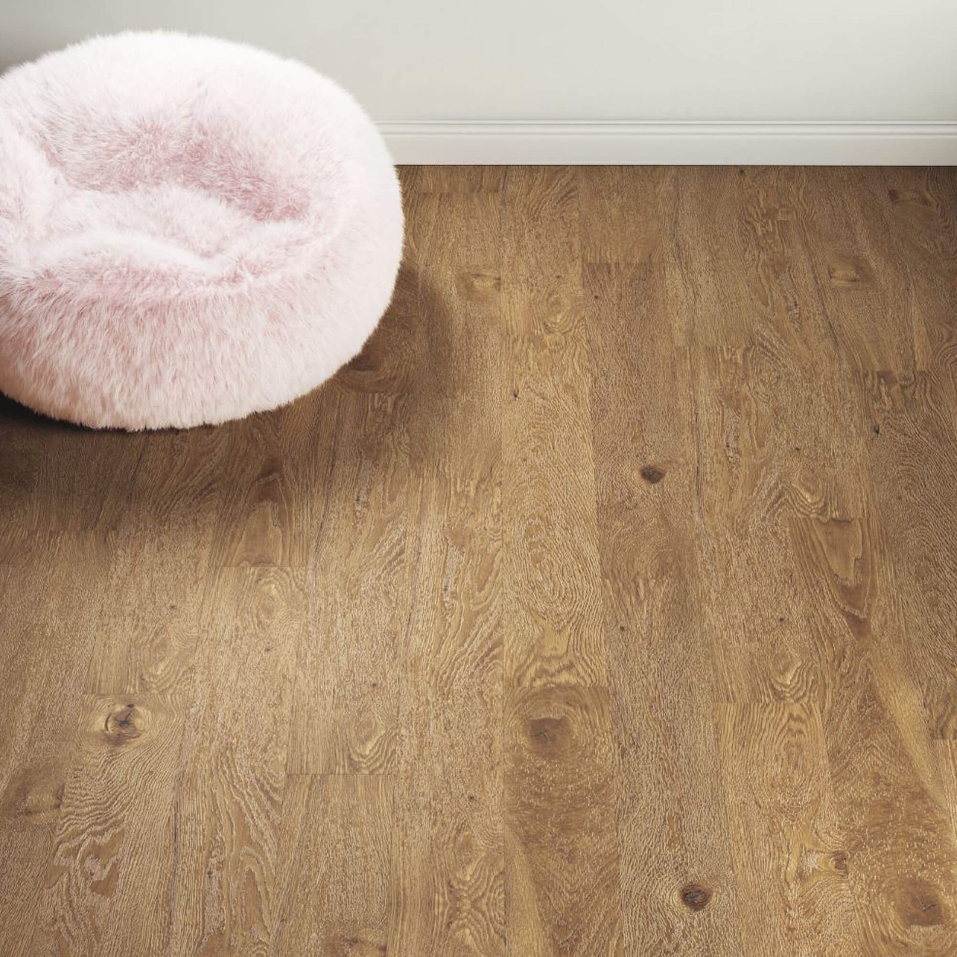 Natural Oak Prestige Laminate Flooring in a home living room setting with a fluffy bean bag in the background.