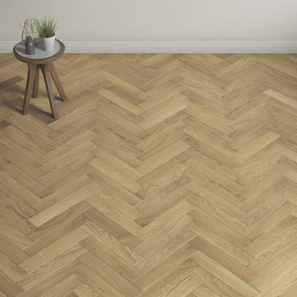 Wide room showing Natural Oak Herringbone UV Oiled 90mm Engineered Wood Flooring and a small round table with plants in the corner.