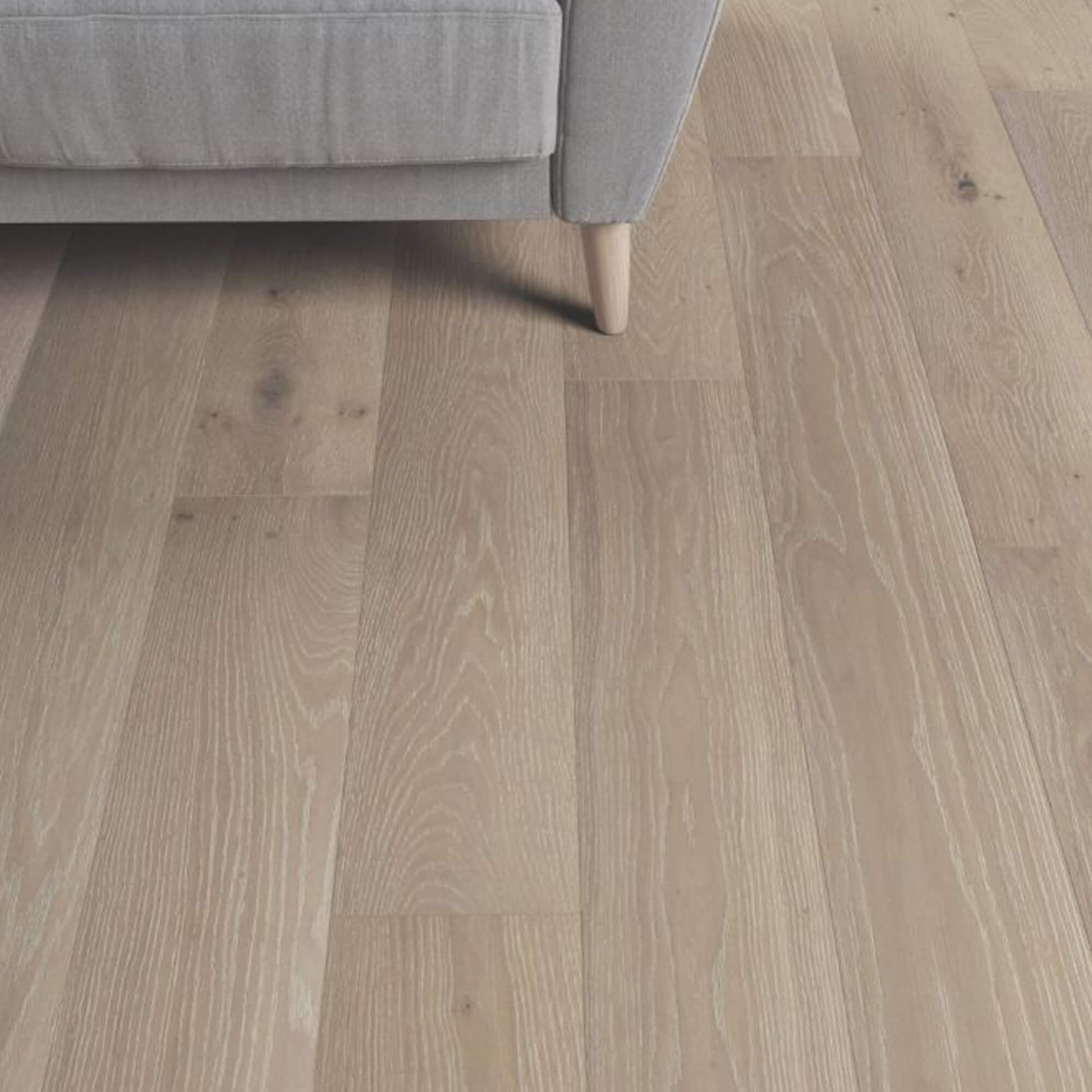 Potters Grey Oak Matt Lacquered 190mm Engineered Wood Flooring with a grey sofa partially visible.