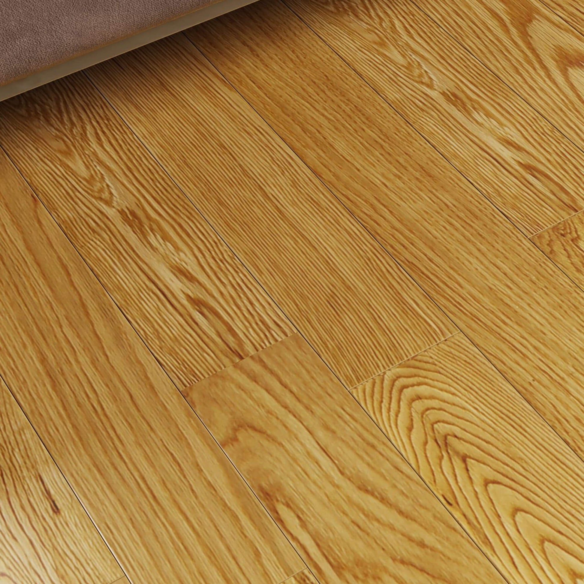Close-up of a Rustic Oak 90mm lacquered wooden floor with visible grain and texture and edge of a sofa.