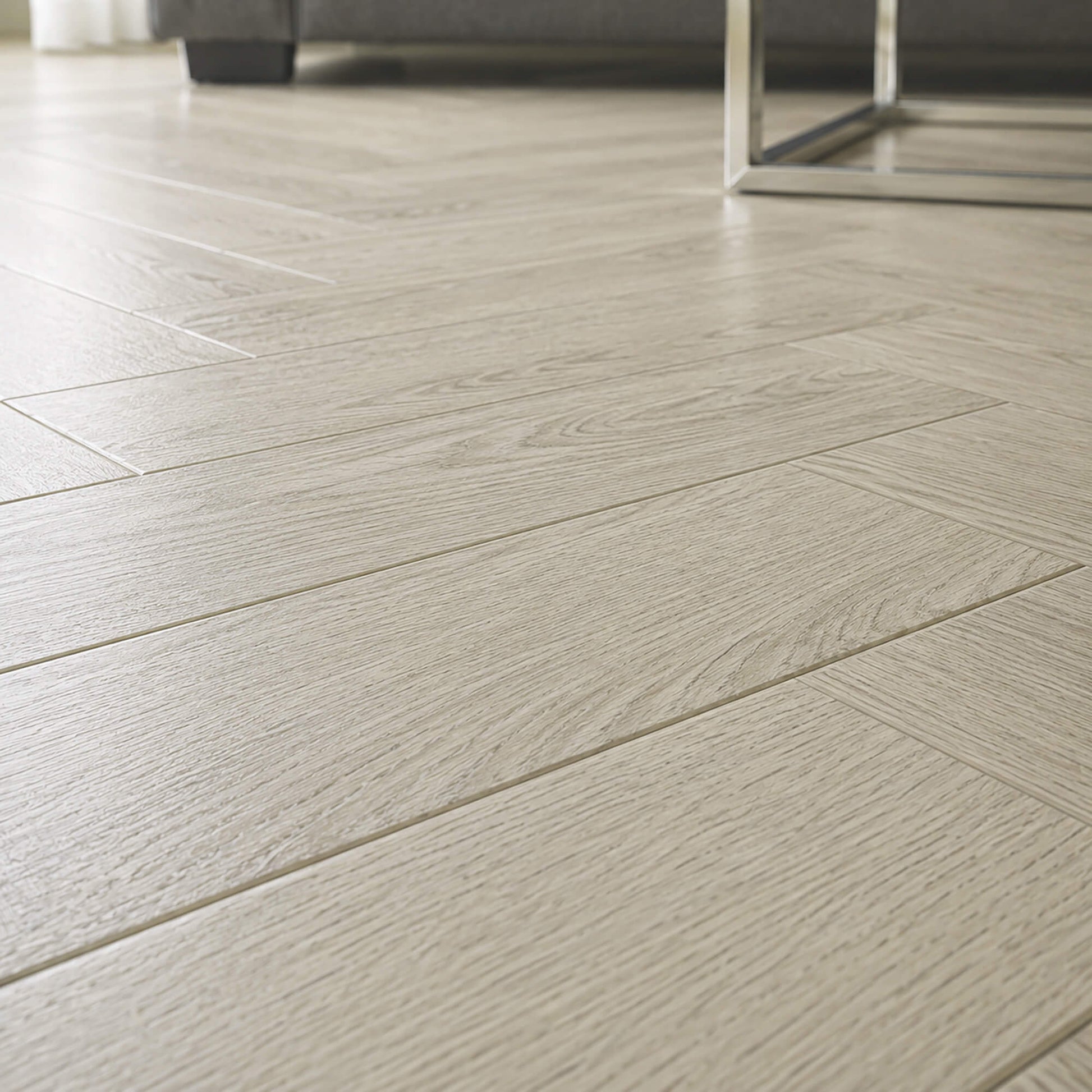 Close-up of Siberian Oak Rigid LVT herringbone flooring in a living room setting.