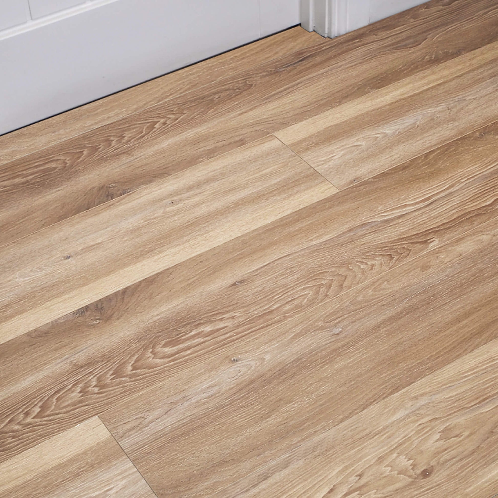 Volcanic Larch Rigid LVT Flooring with white architrave and door in the background.
