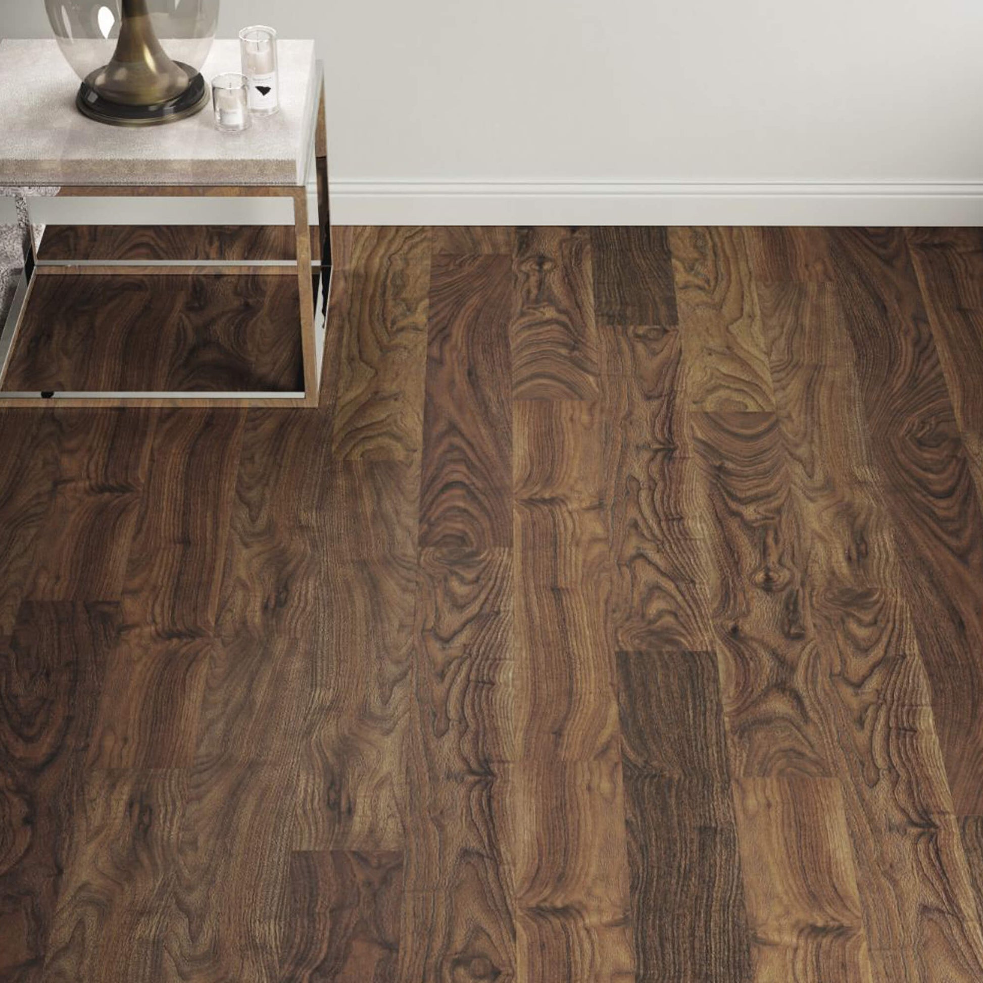 Walnut Prestige Laminate Flooring in a living room background with a table and lamp in the corner.