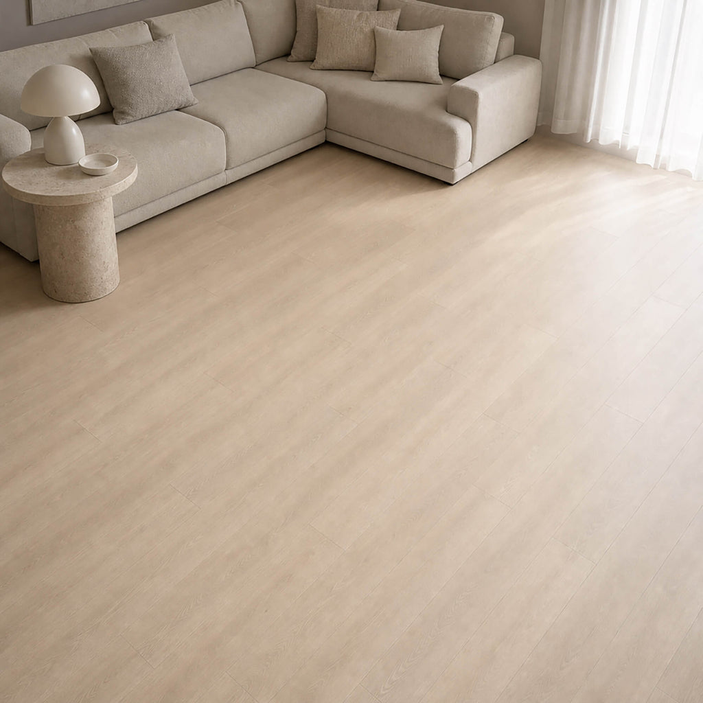 Washed Oak Essentials laminate flooring with a beige sofa in a living room setting.